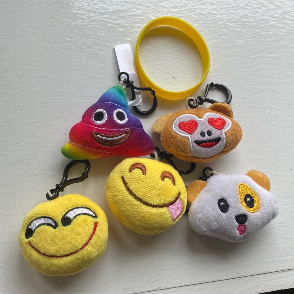 5 key chain emojis and a yellow bracket with smiley faces on it